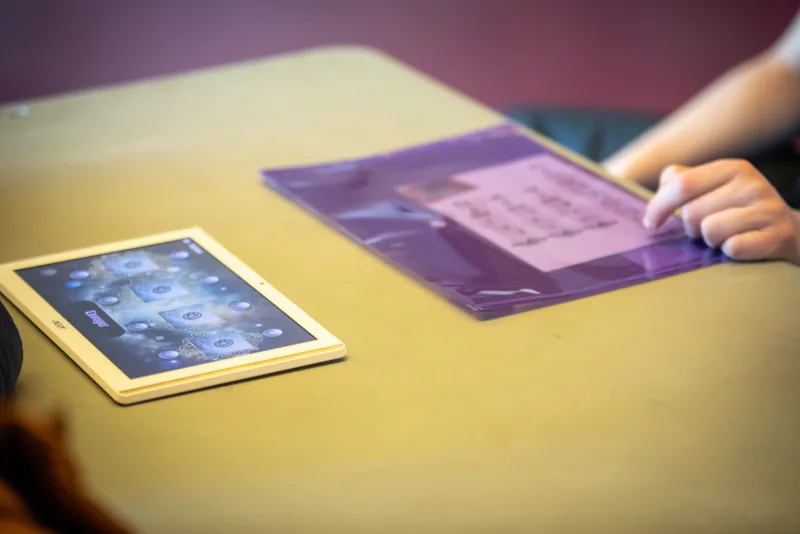 Cartes illustrées et support de jeu sur une table.
