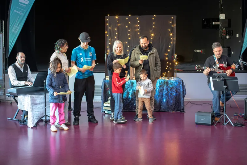 Des participants rejoignent les artistes devant le décor.