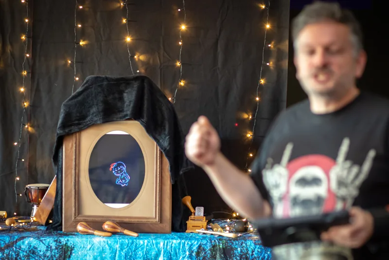 Un personnage lumineux apparaît dans le cadre du décor pendant qu’Eric anime le spectacle.
